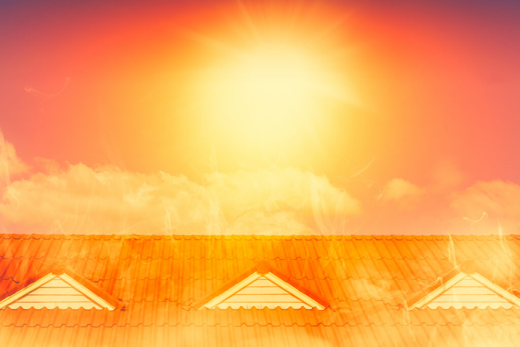 Sun beating down on a residential rooftop with visible heat waves rising from the roof, illustrating extreme summer temperatures, heat exposure, and the impact of intense sunlight on homes.